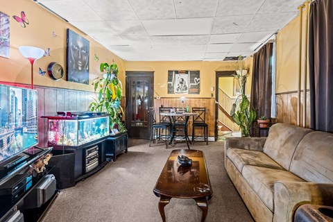A living room with a couch, coffee table, and a fish tank.