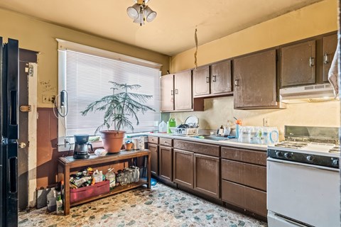 A kitchen with brown cabinets and a white stove.