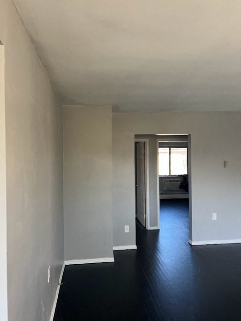 an empty room with white walls and a black floor