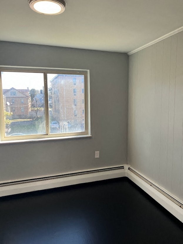 an empty room with a window and a black floor