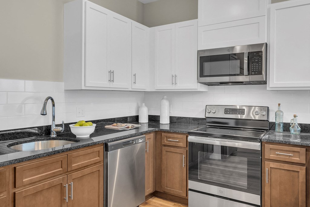 a modern kitchen with stainless steel appliances and white cabinets