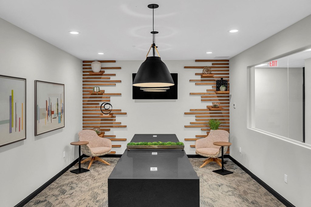 a conference room with two chairs and a table and a wall with wood panels