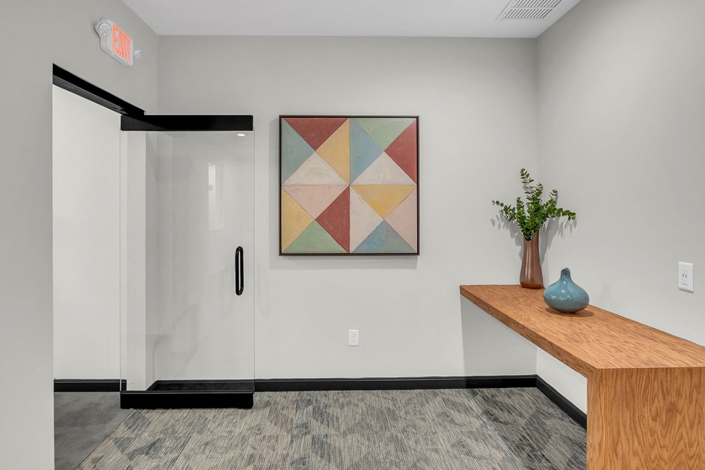 a hallway with a table with a vase and a painting on the wall