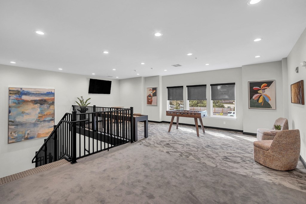 a living room with a staircase and a table and chairs