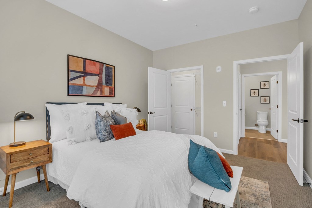 a bedroom with a large bed and a bathroom with a toilet