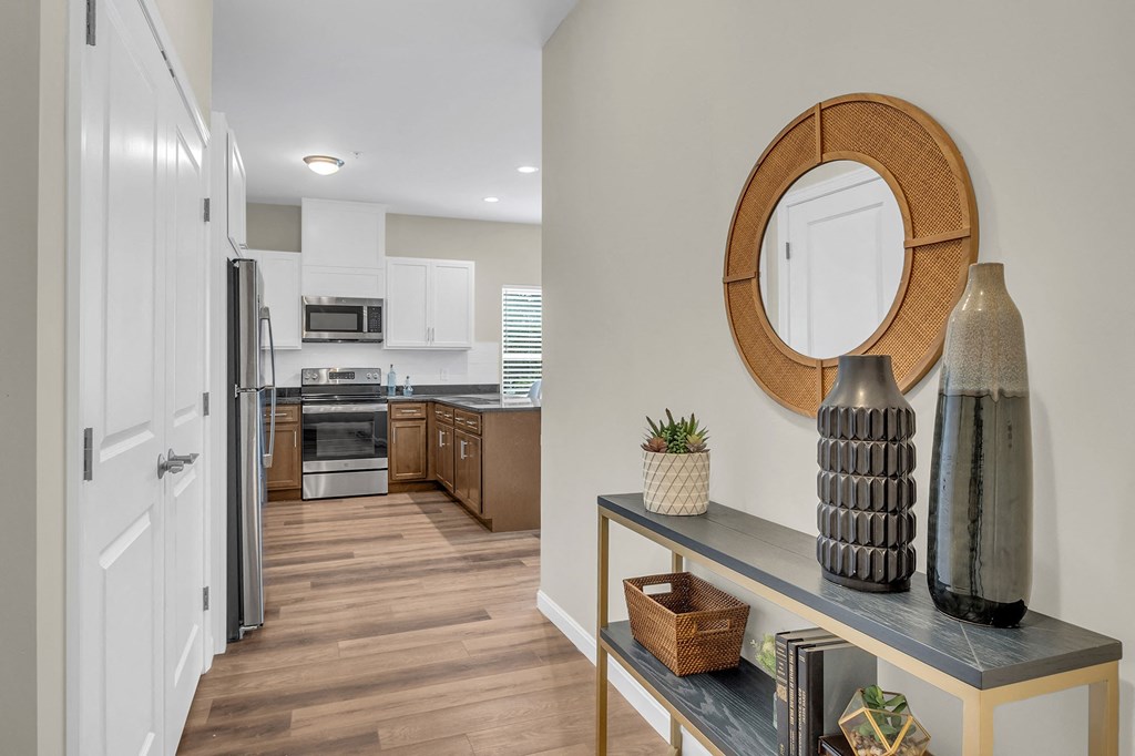 an open kitchen and living room with a table and a mirror