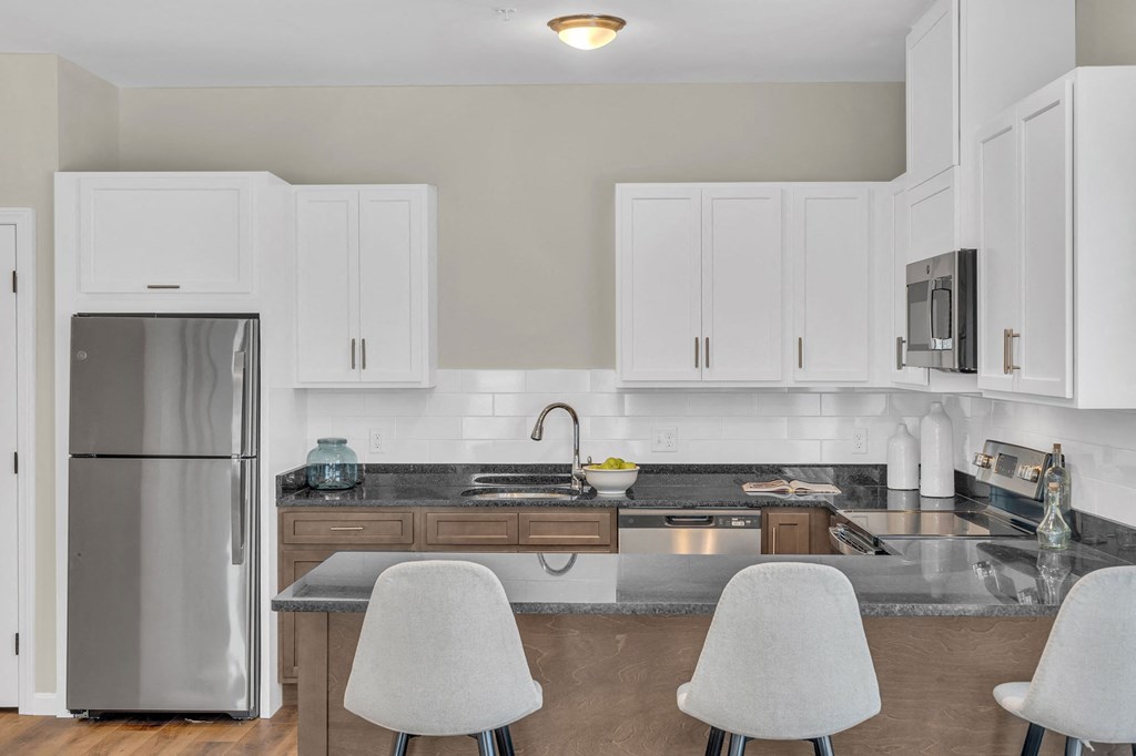 a kitchen with white cabinets and a stainless steel refrigerator