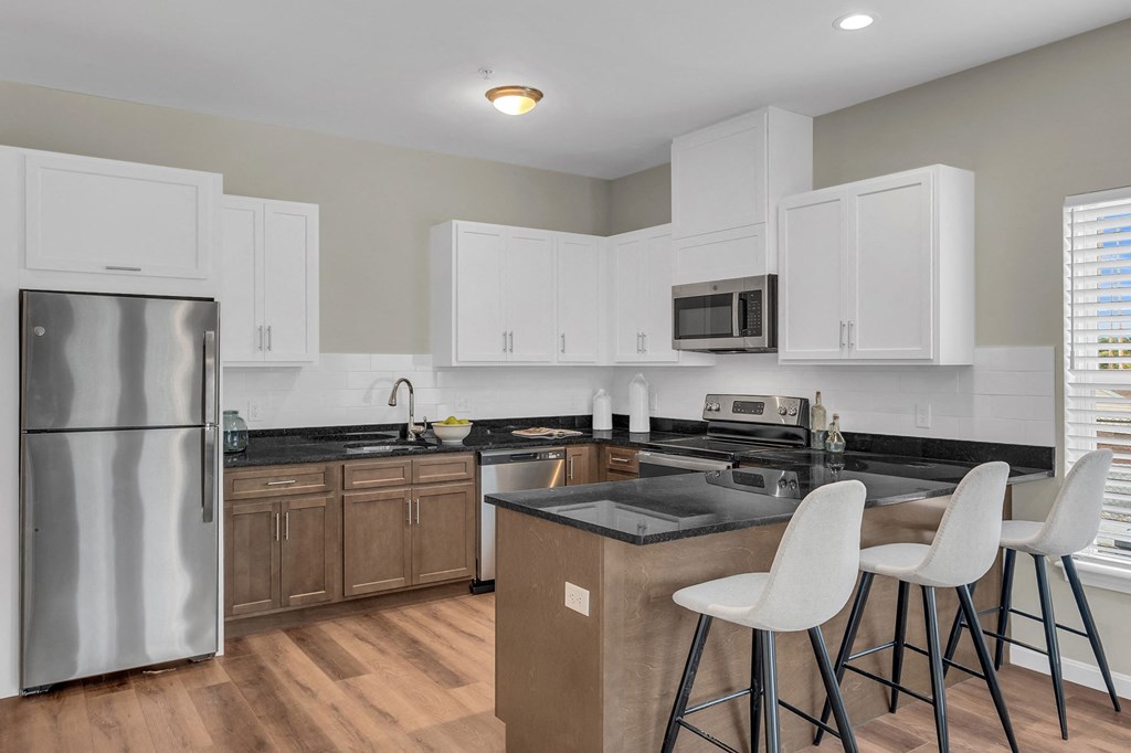 a kitchen with white cabinets and a stainless steel refrigerator