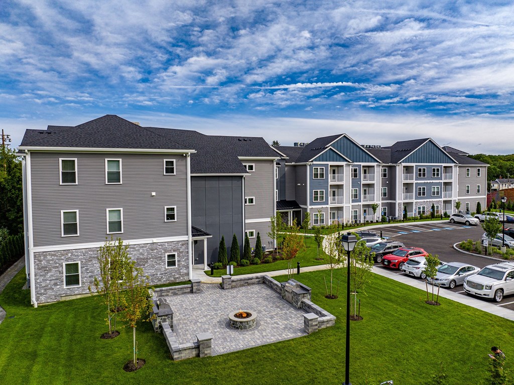 an aerial view of an apartment complex with a fountain and a parking lot