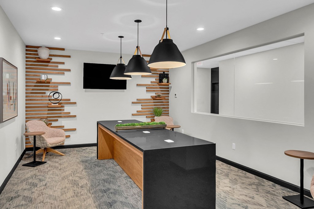 a kitchen with a black counter top and a table and chairs
