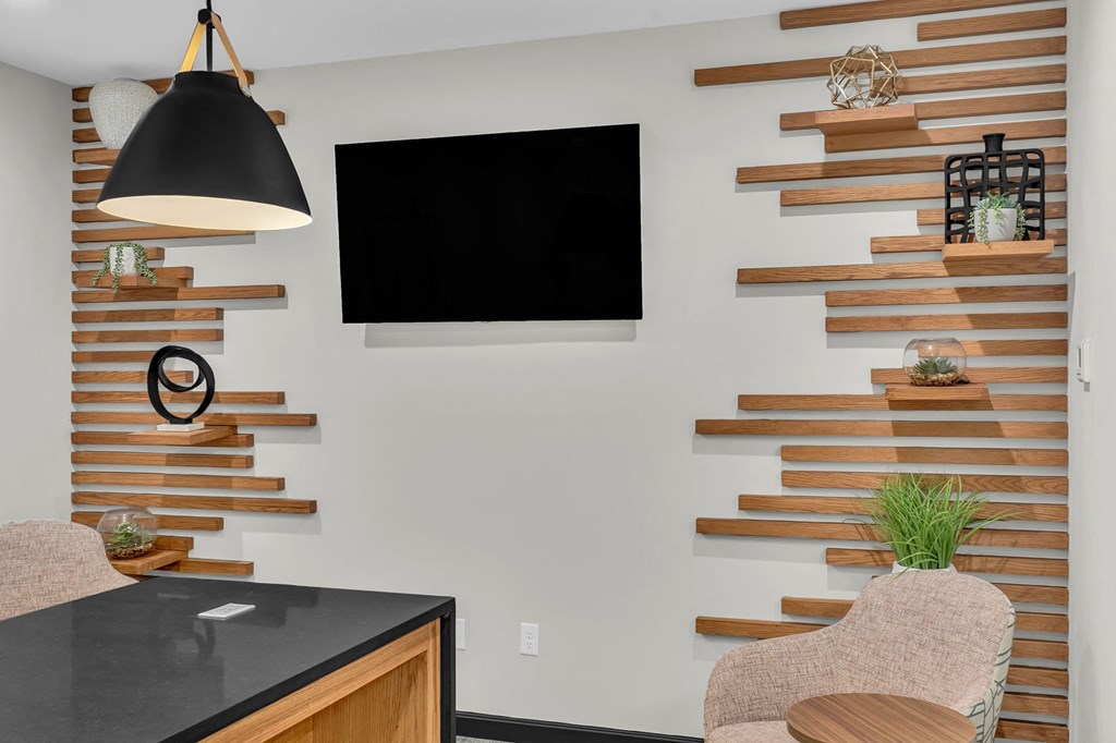 a living room with a tv on the wall and a table and chairs