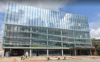 a large glass building with people in front of it
