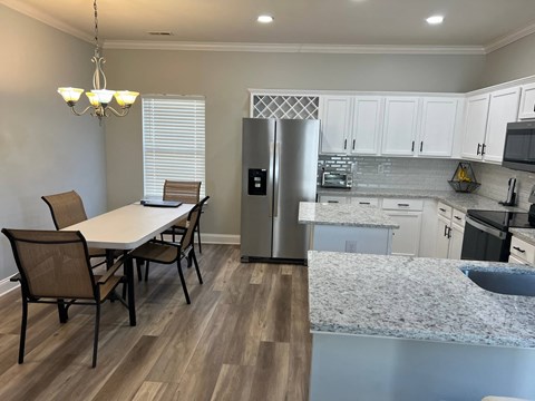 a kitchen and dining area with a stainless steel refrigerator