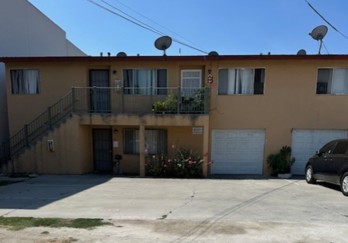 A two-story apartment building with a balcony on the second floor.