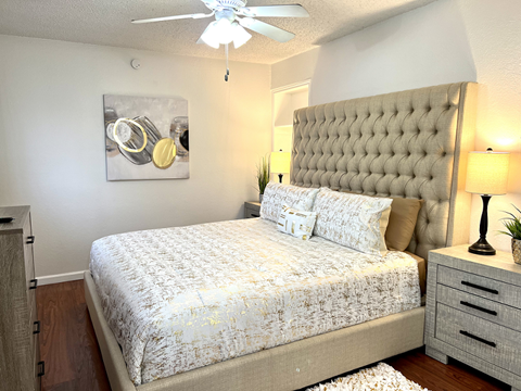 a bedroom with a bed and a ceiling fan