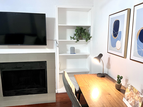 a living room with a table and a fireplace and a television