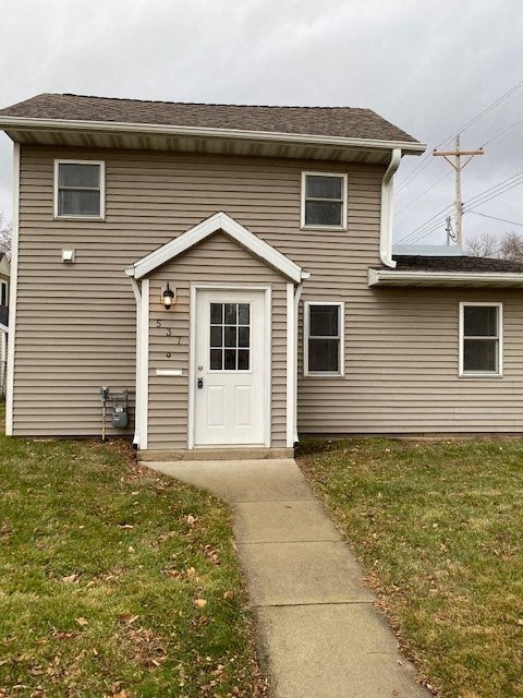 A house with a grey siding and a white door.