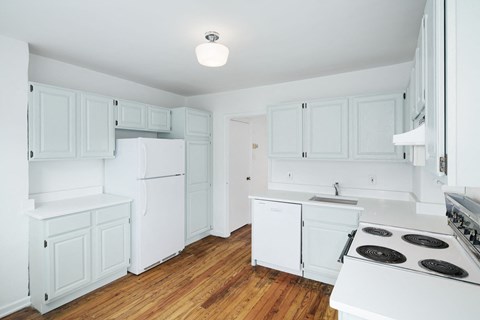 a white kitchen with white cabinets and white appliances