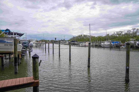 A dock with boats and a sign that says "Bait & Fi" is flooded.