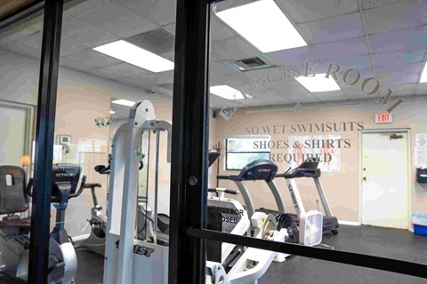 A gym with a sign that says no wet swimsuits, shoes or shirts required.
