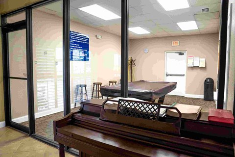 A room with a wooden table and chairs and a whiteboard on the wall.