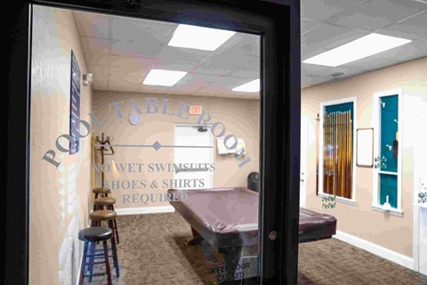 A room with a sign that says "Pool Table" and "Wet Swimsuits, Shoes & Shirts Required.".