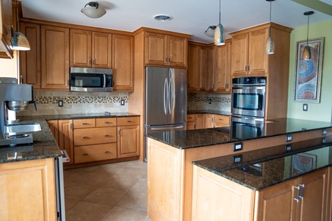 A kitchen with wooden cabinets and a black counter top.