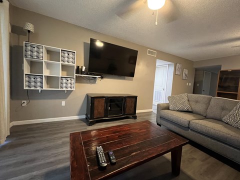 A living room with a grey couch and a wooden coffee table.