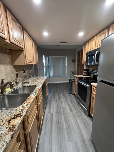 A kitchen with wooden cabinets and a granite countertop.