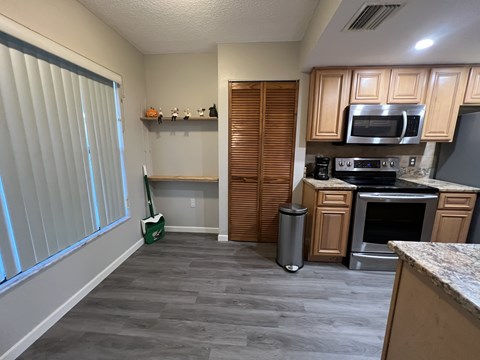 A kitchen with wooden cabinets and a stainless steel oven.