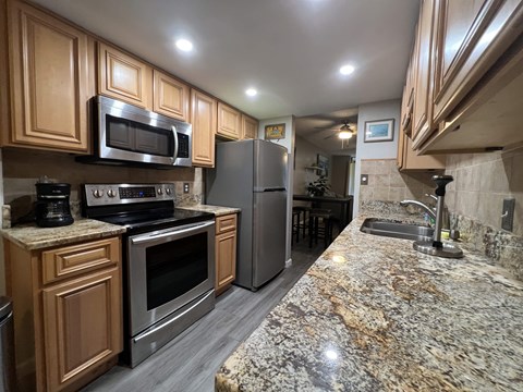 A kitchen with granite countertops and stainless steel appliances.