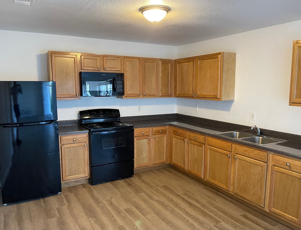 a kitchen with black appliances and wooden cabinets