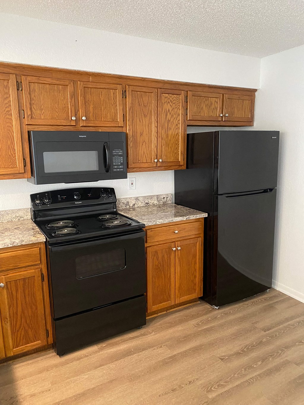 a kitchen with black appliances and wooden cabinets