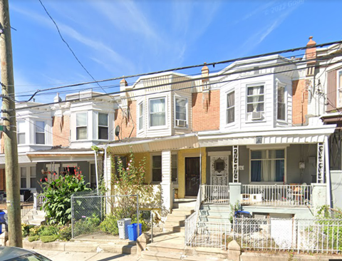 A row of houses with a car parked in front of them.