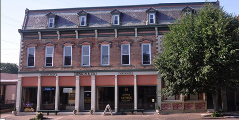 A building with a red awning and a sign that says "14 Antique Store".