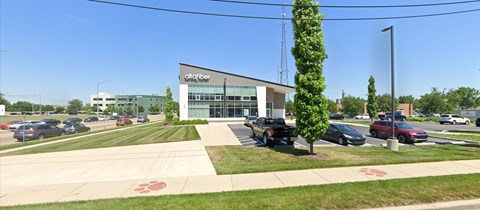 A parking lot with cars and a building with the sign "Clayton Center" in front.