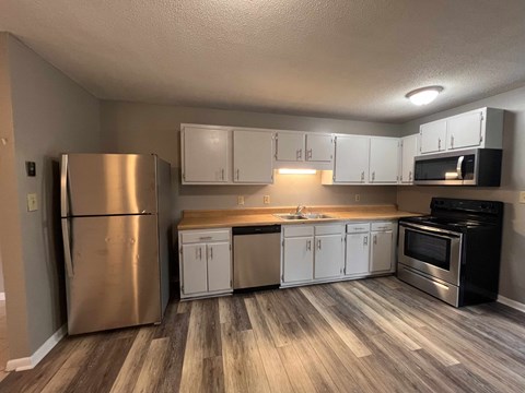 a kitchen with white cabinets and stainless steel appliances