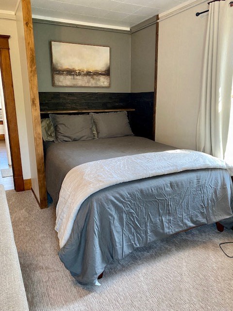 a bedroom with a bed and a painting on the wall