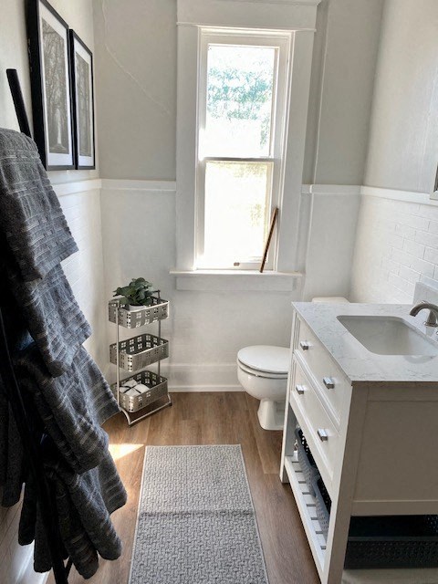 a bathroom with a toilet and a sink and a window