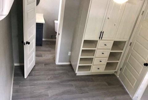 a bathroom with a closet with shelves and a door