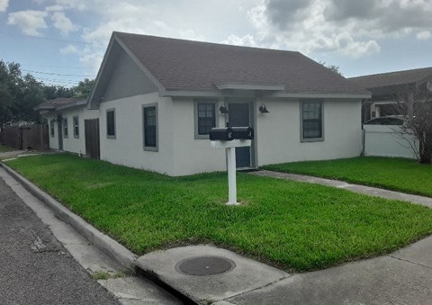 a white house with a mailbox in the grass