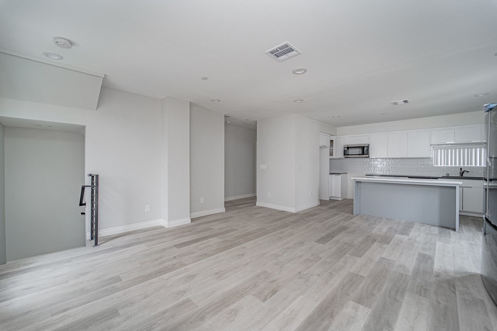 an empty living room and kitchen in a new home