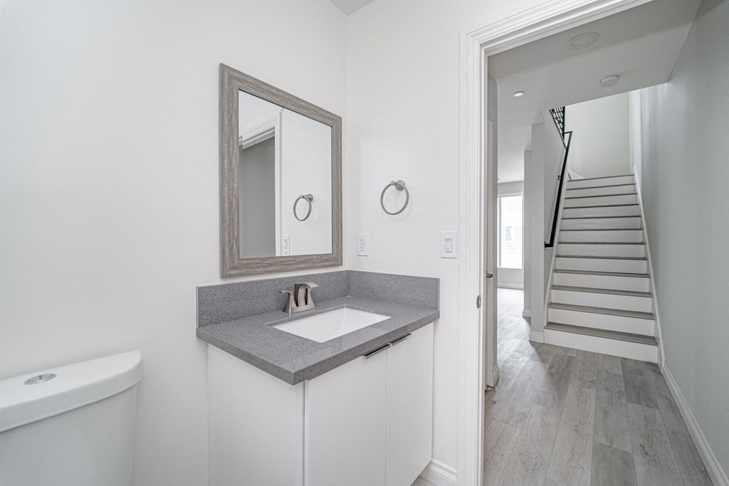 a bathroom with a sink and a mirror and a staircase