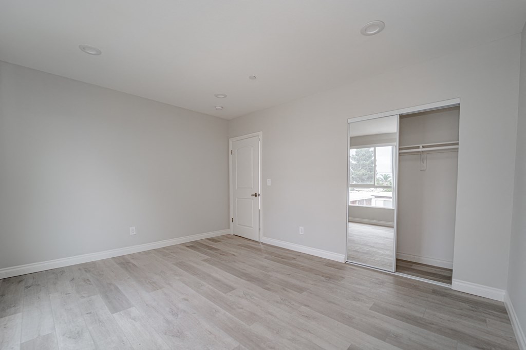 an empty living room with white walls and a sliding glass door