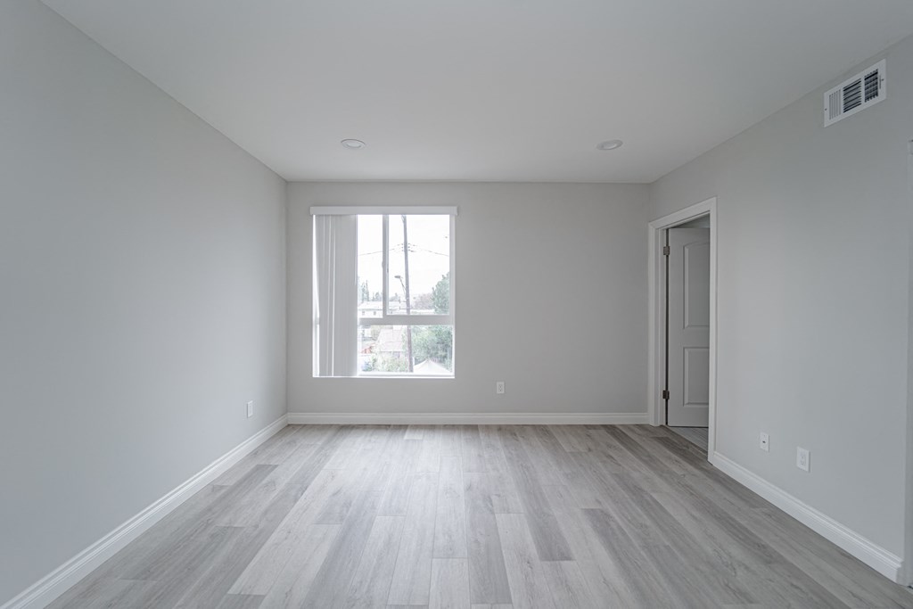 an empty room with white walls and a window