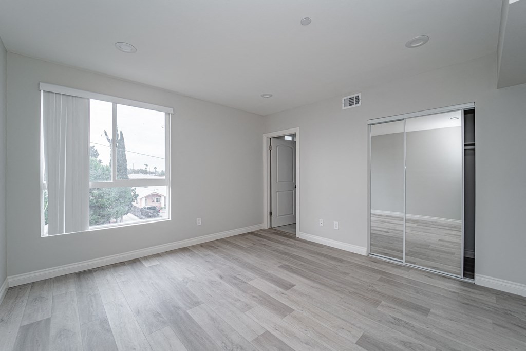 an empty living room with a large window and a door to a closet