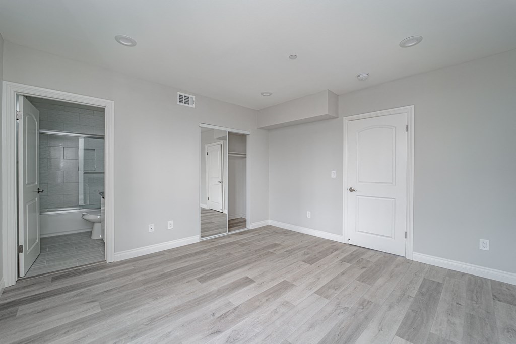 an empty living room with a door to a bathroom
