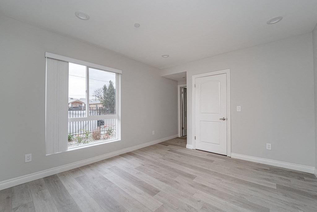 an empty living room with a large window and a door