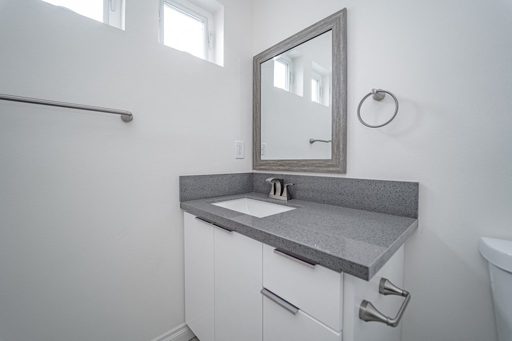an empty bathroom with a sink and a mirror