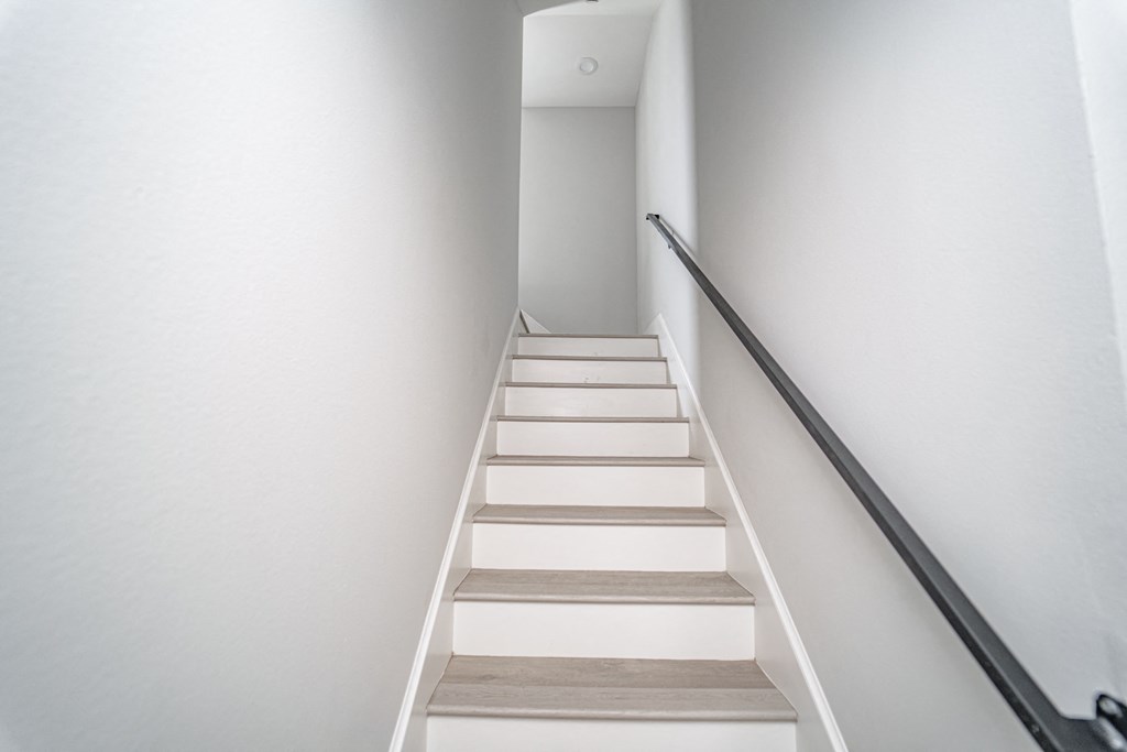 a staircase in a house with white stairs and white walls
